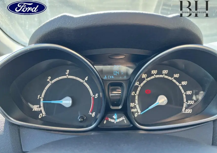 Vue rapprochée du tableau de bord de la Ford Fiesta 2015, avec compte-tours et compteur de vitesse analogiques.