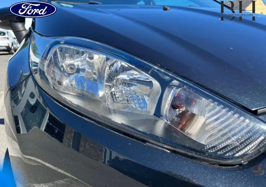 Gros plan sur le phare avant droit d'une Ford Fiesta noire Scala, mettant en valeur les détails du bloc optique.