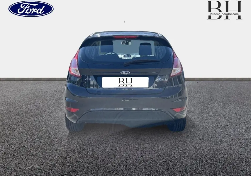 Vue arrière d'une Ford Fiesta noire Scala 2015, avec feux arrière et becquet visibles sur fond neutre.