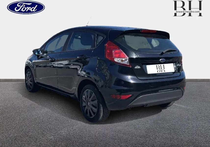 Vue 3/4 arrière droite d'une Ford Fiesta noire Scala avec becquet arrière et feux arrière distinctifs.