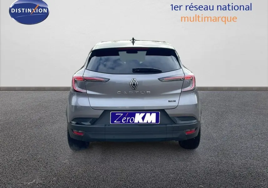 Vue arrière du Renault Captur E-Tech hybride gris Cassiopée métal avec toit noir, feux LED et logo central bien visible.