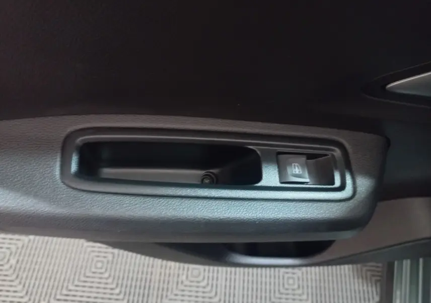 Gros plan sur la commande de lève-vitre côté conducteur de la Dacia Sandero Extreme+ TCe 110 verte 2024.