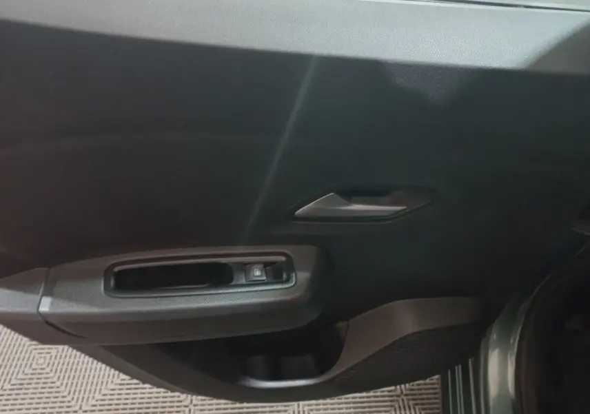 Vue intérieure du panneau de porte côté conducteur vert foncé de la Dacia Sandero Extreme+ TCe 110 2024 avec commande de lève-vitre électrique.