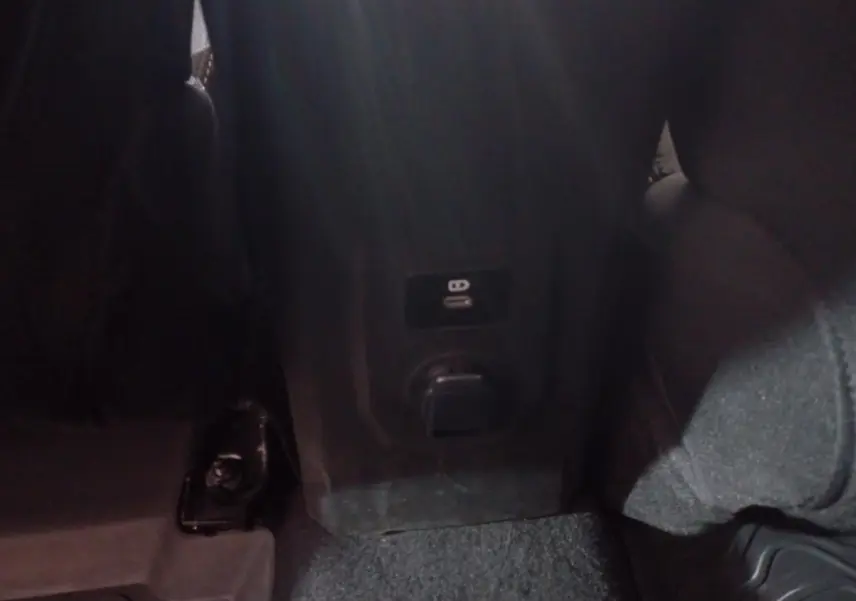 Prise USB et prise 12V arrière sur la console centrale d'une Dacia Sandero Extreme+ TCe 110 verte, vue intérieure arrière.