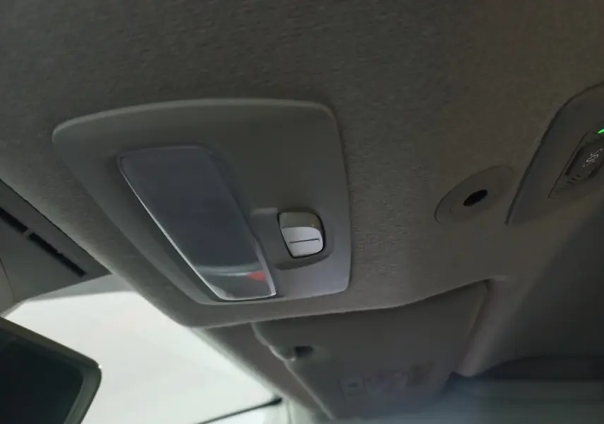 Plafonnier intérieur gris avec commande d’éclairage, vue du toit avant de la Dacia Sandero 2024.