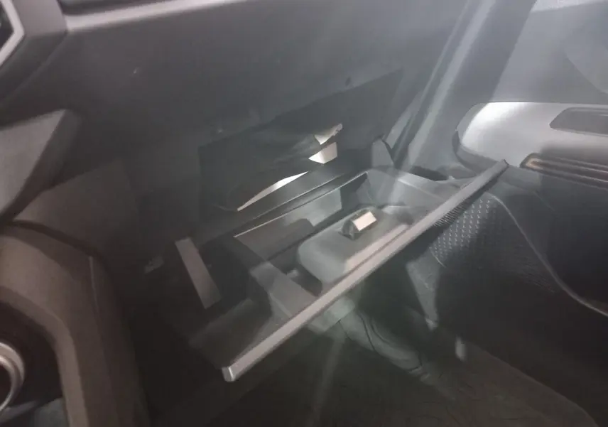 Gant de boîte à gants ouvert côté passager dans l’habitacle sombre d’une Dacia Sandero 2024.