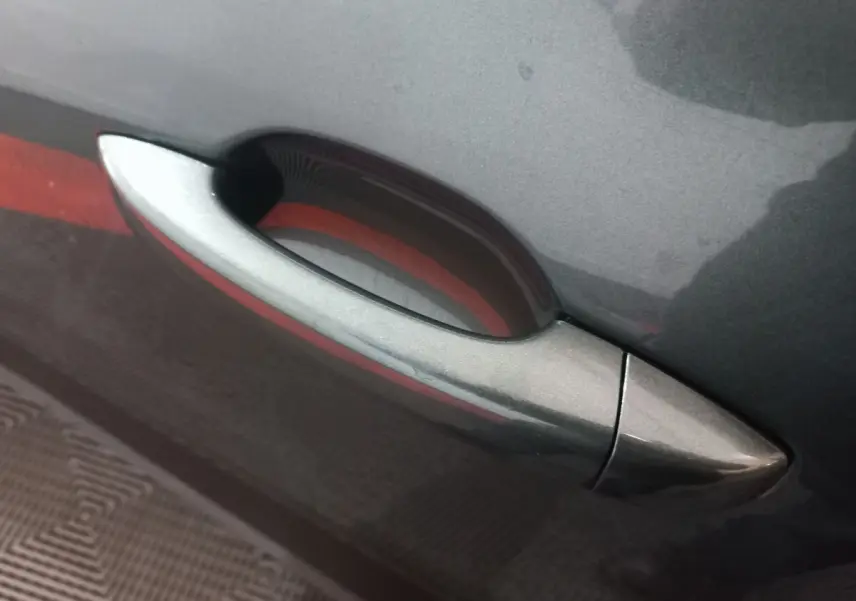 Poignée de porte côté droit gris métallisé sur Dacia Sandero Extreme+ TCe 110 -24, détail extérieur rapproché.