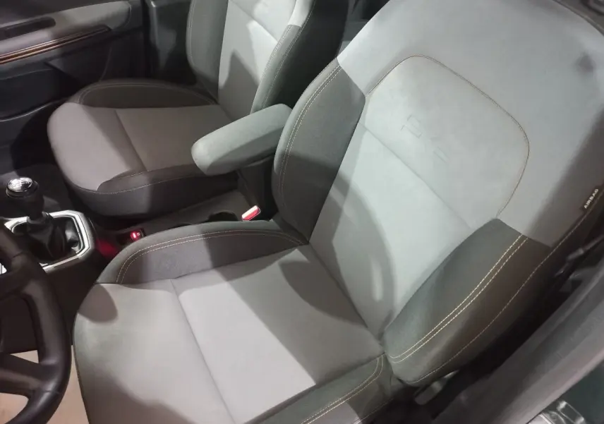 Vue intérieure rapprochée des sièges avant gris du Dacia Sandero Extreme+ TCe 110 2024 avec levier de vitesse manuel.