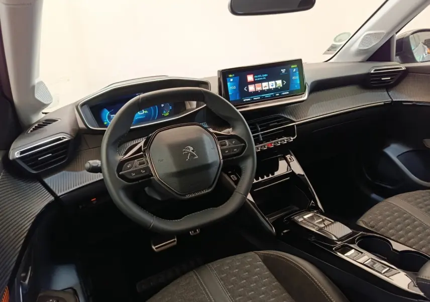 Vue intérieure de face du tableau de bord et volant cuir noir de la Peugeot 208 Electrique Roadtrip 2022 avec écran tactile central.