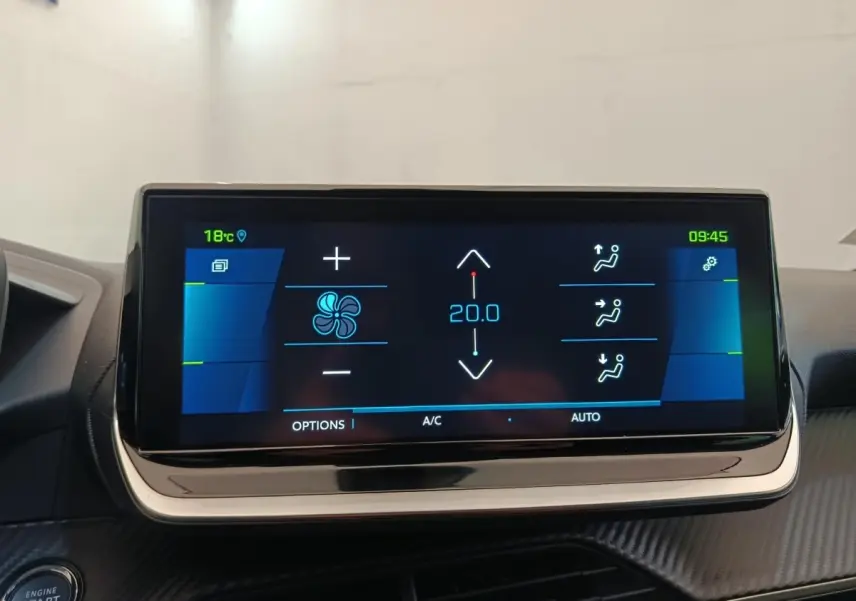 Écran tactile central de la Peugeot 208 Electrique gris clair, affichant la climatisation à 20°C en gros plan.