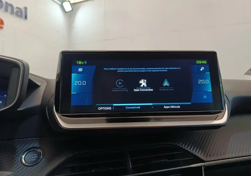 Écran tactile central de 10 pouces affichant Apple CarPlay et Android Auto dans le tableau de bord d’une Peugeot 208 Electrique gris clair.