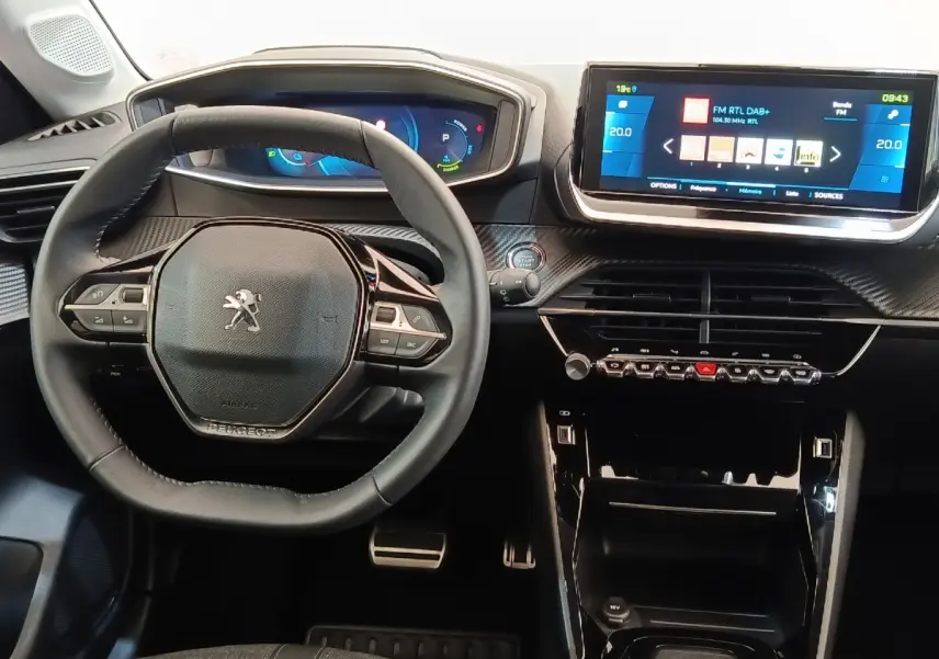 Vue intérieure centrée sur le volant cuir et le tableau de bord avec écran tactile de la Peugeot 208 électrique gris clair.