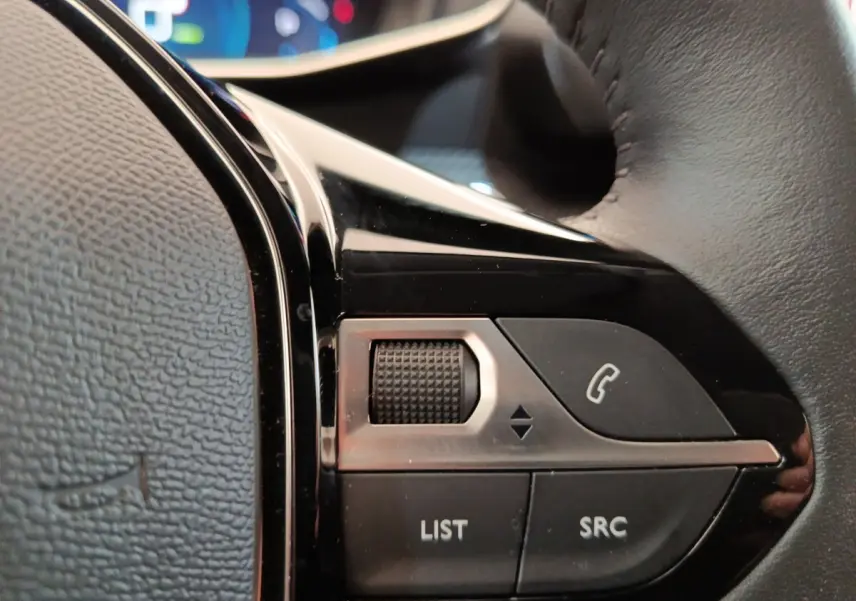 Gros plan sur les commandes au volant cuir noir de la Peugeot 208 Electrique Roadtrip 2022, boutons multifonctions.