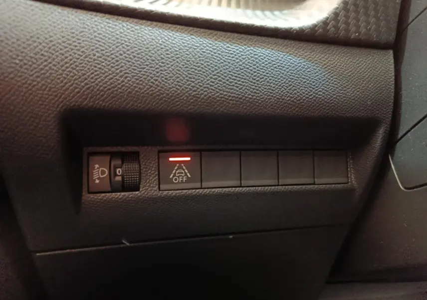 Détail intérieur du tableau de bord côté gauche avec commande d’éclairage et bouton d’alerte franchissement de ligne activé.