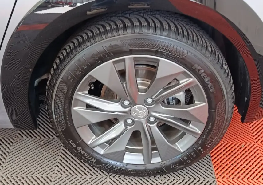 Gros plan sur la roue avant droite gris clair d'une Peugeot 208 Electrique Roadtrip 2022 avec jante alliage moderne.