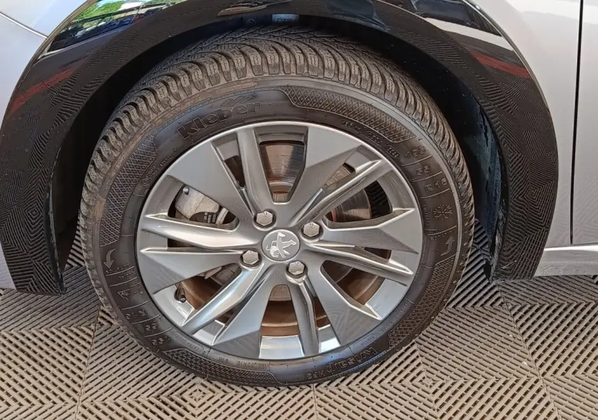 Gros plan sur la roue avant droite gris clair d'une Peugeot 208 Electrique ROADTRIP 2022 avec jante alliage.