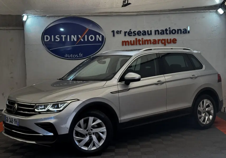 Volkswagen Tiguan gris clair vu de profil droit en intérieur avec jantes alliage et toit ouvrant chromé.