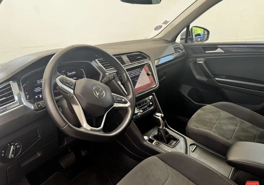 Intérieur Volkswagen Tiguan 1.5 TSI 2021 vu côté conducteur, volant cuir, écran tactile central et sièges tissu gris.