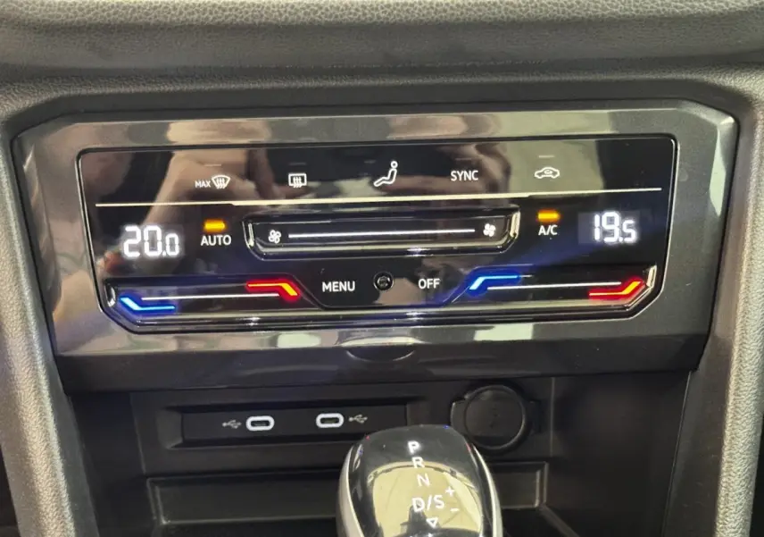 Détail du panneau de climatisation digital et levier de vitesse automatique dans un Volkswagen Tiguan gris clair 2021.