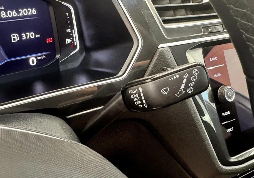 Gros plan sur la commande des essuie-glaces et le tableau de bord numérique du Volkswagen Tiguan gris clair 2021.