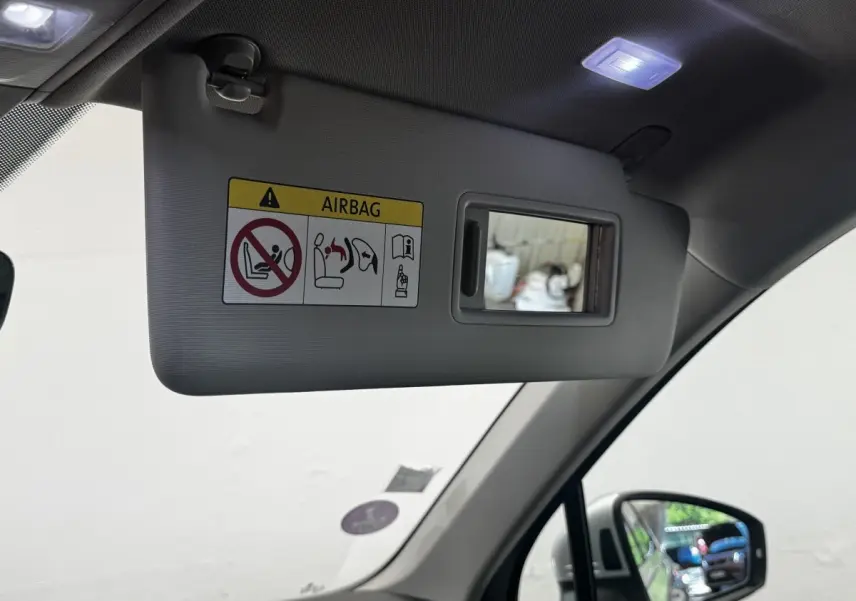 Détail du pare-soleil côté conducteur gris avec miroir intégré et avertissement airbag, intérieur Volkswagen Tiguan 2021.