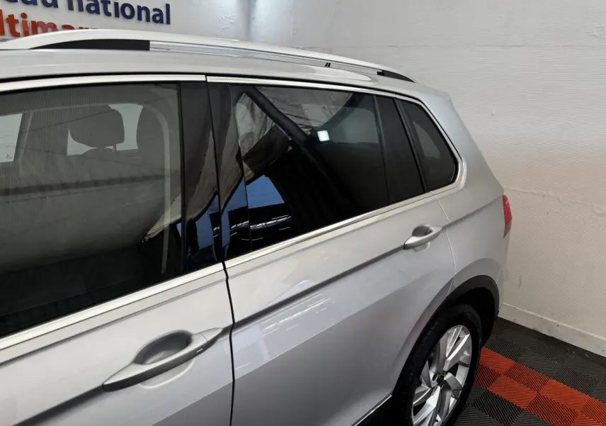 Vue côté droit arrière d'un Volkswagen Tiguan gris clair 2021 avec vitres teintées et jantes alliage.