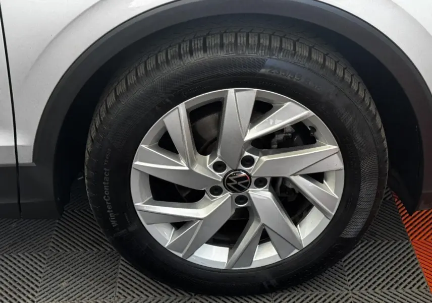 Gros plan sur la roue avant gauche gris clair du Volkswagen Tiguan 1.5 TSI 150 DSG7 Elegance avec jante alliage à cinq branches doubles.