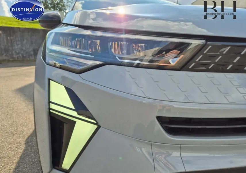 Gros plan sur l'avant gauche du Renault Captur 2025 bleu Iron métallisé, mettant en valeur ses phares et feux LED distinctifs.