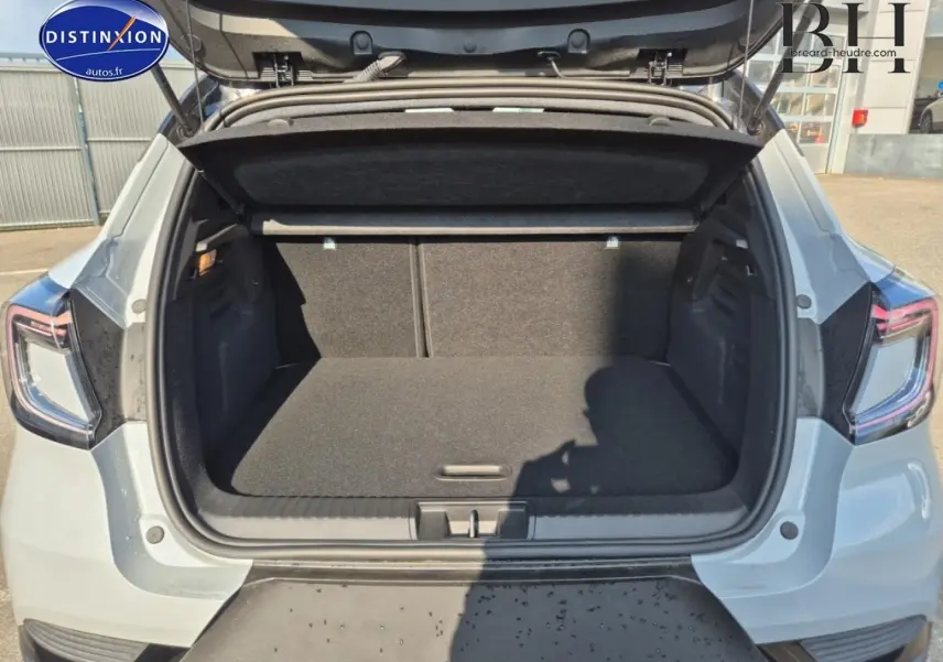 Coffre ouvert vu de l'arrière d'un Renault Captur 2025 bleu Iron métallisé avec feux arrière LED visibles.