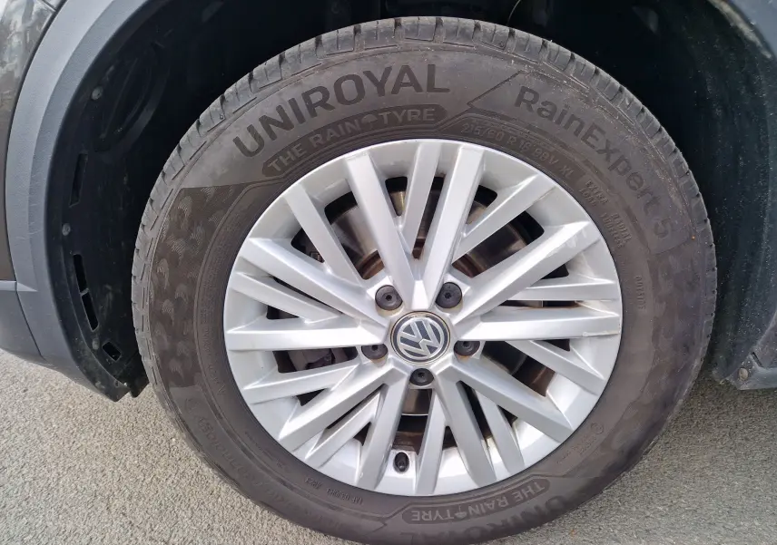 Gros plan sur la roue avant gauche d'un Volkswagen T-Roc Chêne Noir, avec jante alliage et pneu Uniroyal RainExpert 5.
