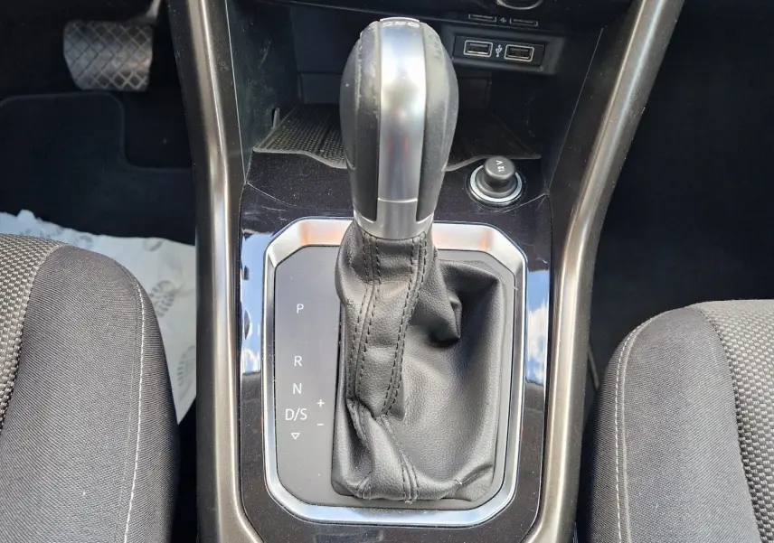 Gros plan sur la console centrale du Volkswagen T-Roc 2.0 TDi Lounge avec levier de vitesse automatique et commandes de climatisation.
