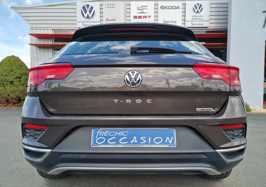 Vue arrière d'un Volkswagen T-Roc chêne noir avec logo 4Motion et feux arrière LED visibles.