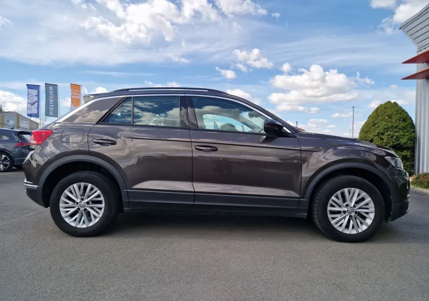 Profil côté gauche d'un Volkswagen T-Roc Chêne Noir 2.0 TDi 150 ch 4 Motion Lounge avec jantes alliage et toit noir.