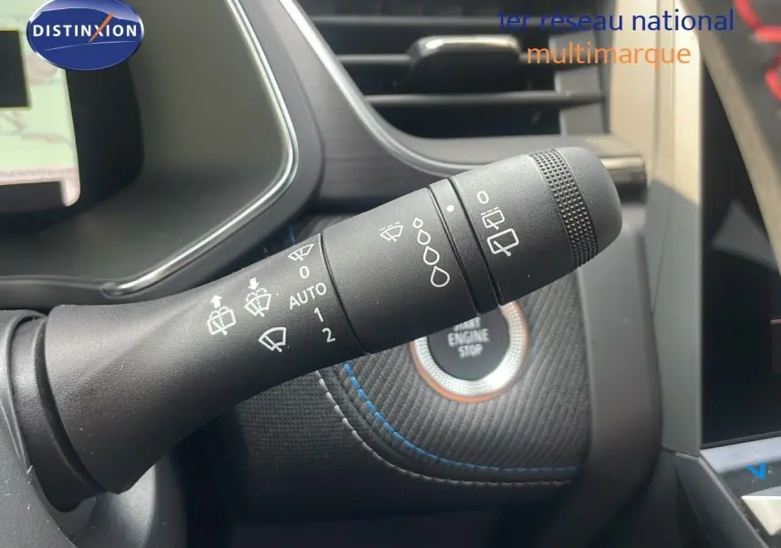 Gros plan sur la commande des essuie-glaces du Renault Captur E-Tech gris Cassiopée, avec bouton start/stop en arrière-plan.