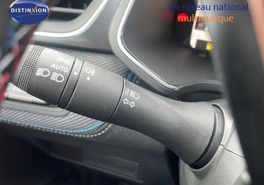 Gros plan sur la commande des phares et clignotants du Renault Captur E-Tech gris cassiopée avec surpiqûres bleues.