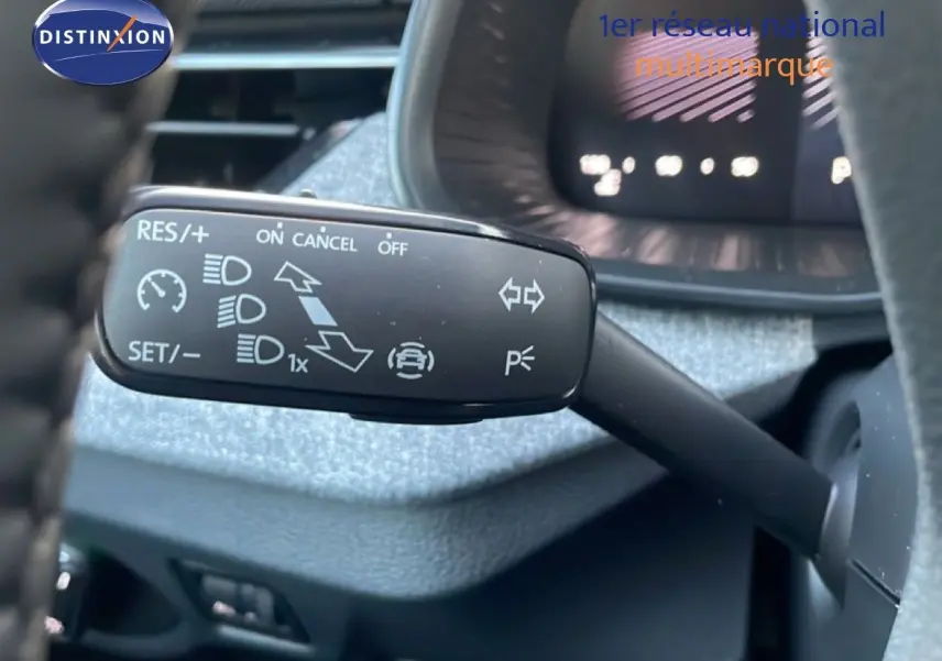 Gros plan sur la commande de régulateur de vitesse à gauche du volant d’un Skoda Kamiq gris argent.