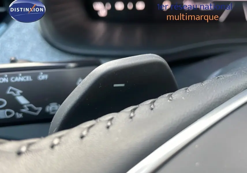 Gros plan sur la palette de changement de vitesse derrière le volant en cuir noir du Skoda Kamiq gris argent.