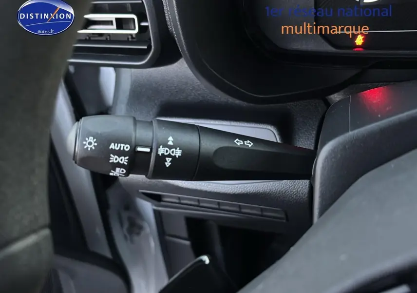 Gros plan sur la commande des feux et clignotants à gauche du volant dans le Citroën Berlingo Fourgon blanc 2025.
