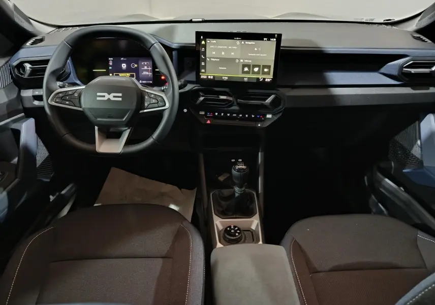 Vue intérieure avant du tableau de bord et volant du Dacia Bigster 2025 avec écran tactile et boîte manuelle.