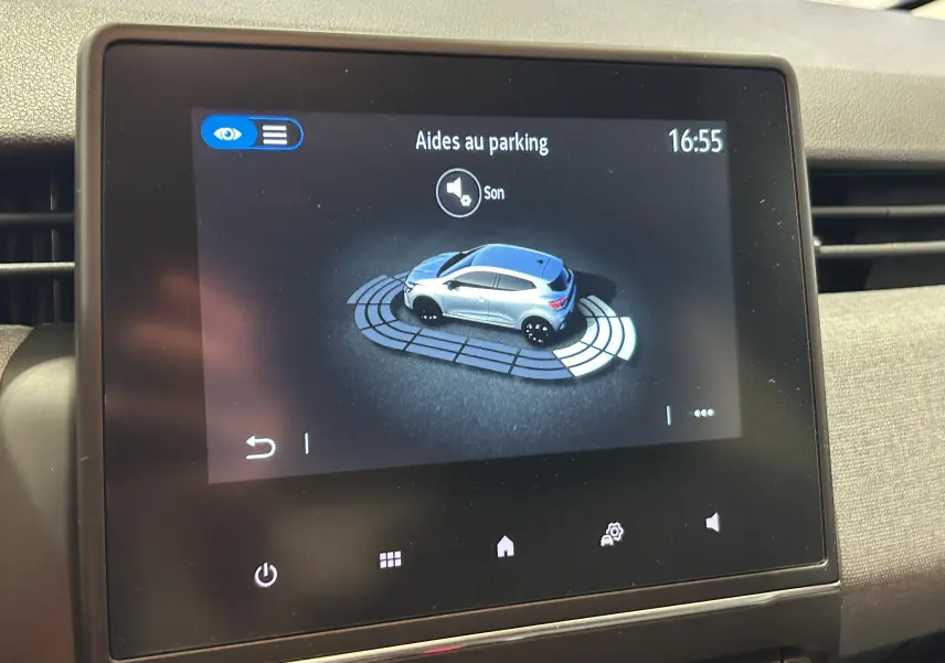 Écran tactile intérieur montrant l'aide au parking avec une illustration 3D d'une Renault Clio blanche vue de côté.