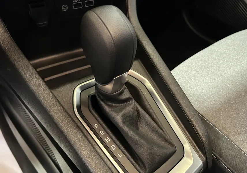 Le levier de vitesse automatique noir de la Renault Clio V TCE 90CH, avec console et siège tissu gris visible.