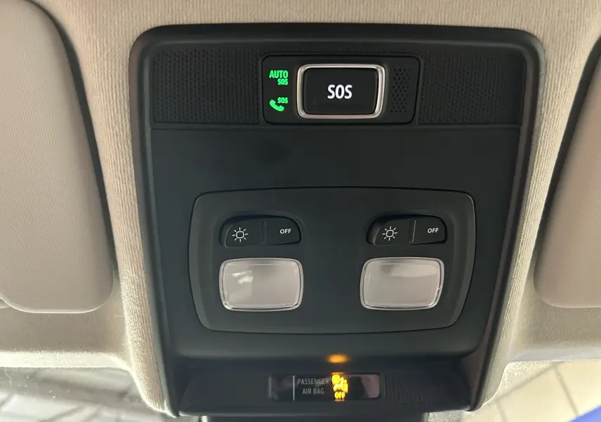 Vue en gros plan du plafonnier intérieur avec boutons d’éclairage et alerte SOS sur Renault Clio V blanche.