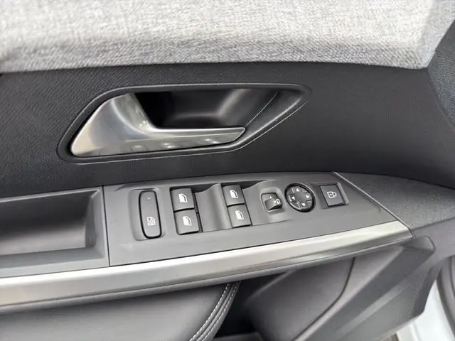 Vue rapprochée de la porte côté conducteur du Peugeot 5008 blanc, avec commandes électriques des vitres et rétroviseurs.