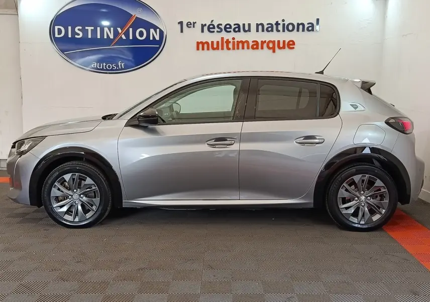 Profil droit d'une Peugeot 208 électrique Roadtrip gris clair, avec jantes alliage et poignées de porte chromées.