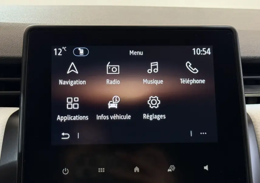 Écran tactile central de la Renault Clio blanc, affichant le menu principal avec navigation et radio à 10h54.