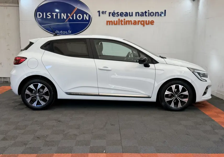 Profil droit d'une Renault Clio blanche 2023 Evolution TCe 100 GPL avec jantes alliage et rétroviseurs noirs.