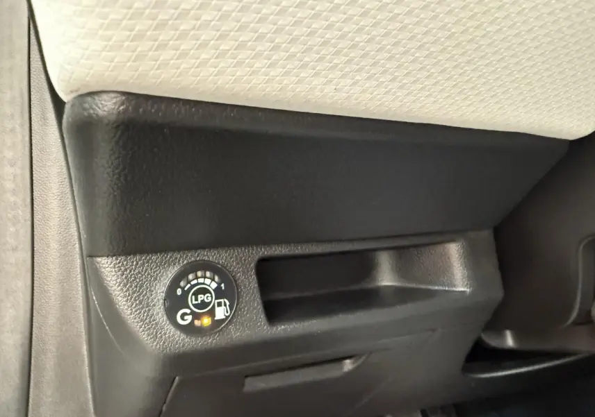 Gros plan sur le tableau de bord noir avec indicateur de carburant GPL allumé dans une Renault Clio blanche.