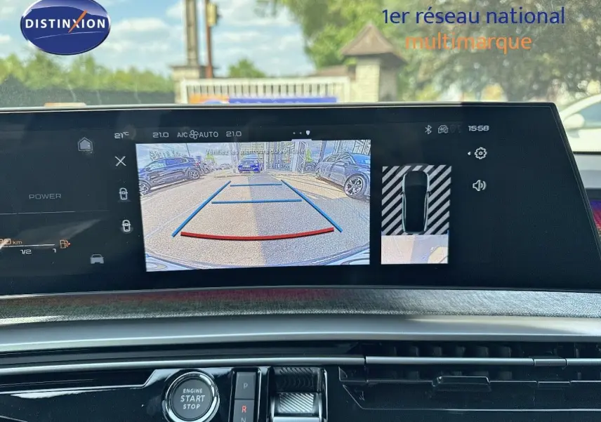 Vue intérieure du tableau de bord du Peugeot 3008 blanc Okenite 2025, écran affichant la caméra de recul et les commandes.