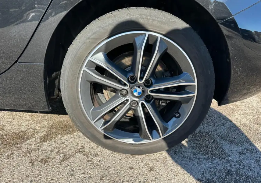 Gros plan sur la jante alliage 17 pouces noire d'une BMW Série 1 F40 118d, avec logo BMW au centre.
