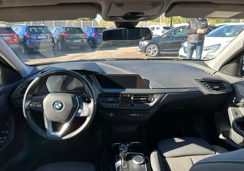 Intérieur noir de BMW Série 1 F40 118d 2021, vue frontale du tableau de bord et volant cuir sport avec commandes intégrées.